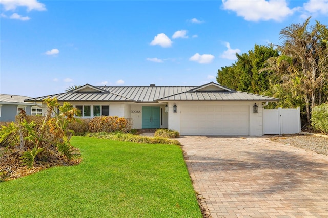 ranch-style house featuring a garage and a front lawn