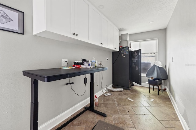 clothes washing area with a textured ceiling