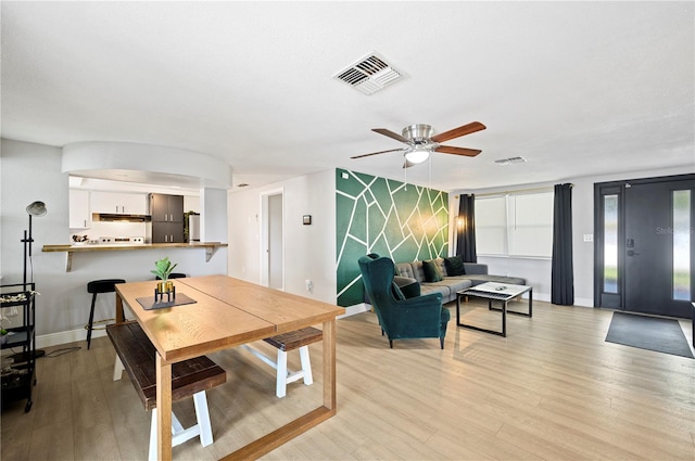 living room featuring a wealth of natural light, light hardwood / wood-style flooring, and ceiling fan