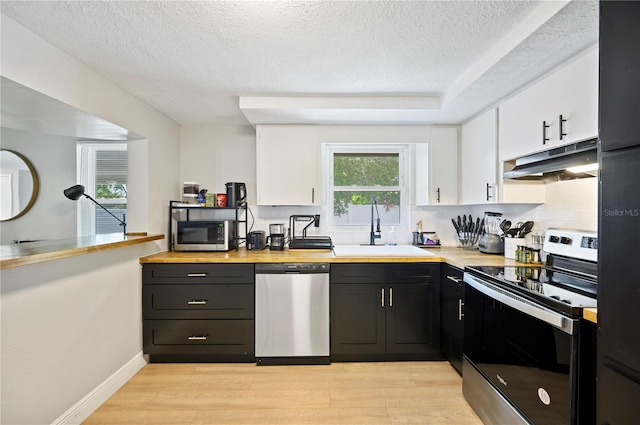 kitchen featuring white cabinets, light hardwood / wood-style floors, stainless steel appliances, and sink