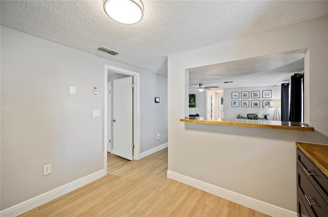 kitchen featuring ceiling fan, a textured ceiling, and light hardwood / wood-style floors