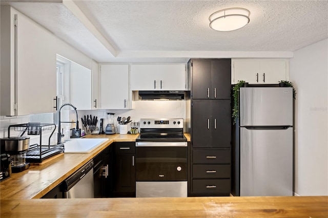 kitchen featuring white cabinets, a textured ceiling, sink, backsplash, and appliances with stainless steel finishes