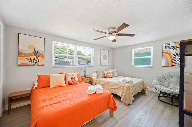 bedroom featuring hardwood / wood-style floors, ceiling fan, and a textured ceiling