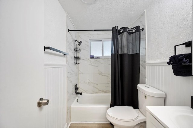 full bathroom featuring vanity, shower / bath combo with shower curtain, a textured ceiling, and toilet