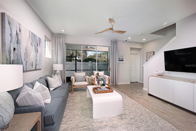 living room with light hardwood / wood-style floors and ceiling fan