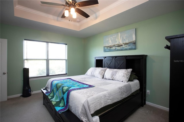 carpeted bedroom with a raised ceiling, ceiling fan, and ornamental molding