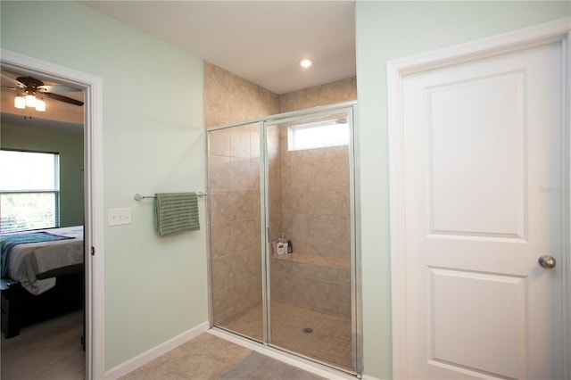 bathroom with tile patterned floors, plenty of natural light, a shower with shower door, and ceiling fan