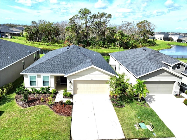 view of front of home featuring a garage, a water view, and a front lawn