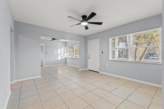 tiled empty room featuring ceiling fan