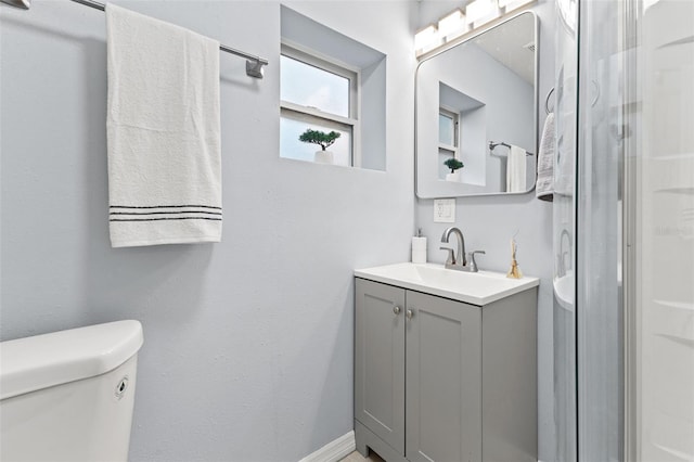 bathroom with vanity, toilet, and a shower with shower door