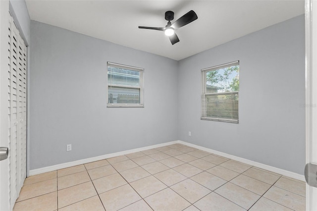 tiled empty room featuring ceiling fan