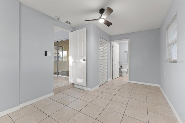 unfurnished bedroom featuring ceiling fan, light tile patterned floors, and connected bathroom