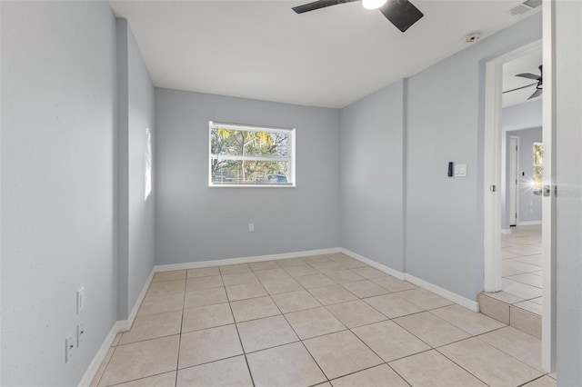 tiled spare room featuring ceiling fan