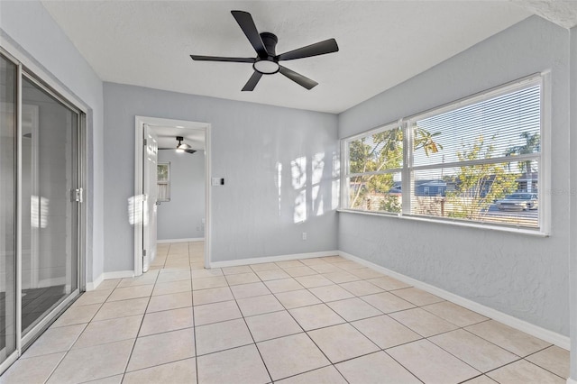 tiled empty room featuring ceiling fan and a textured ceiling