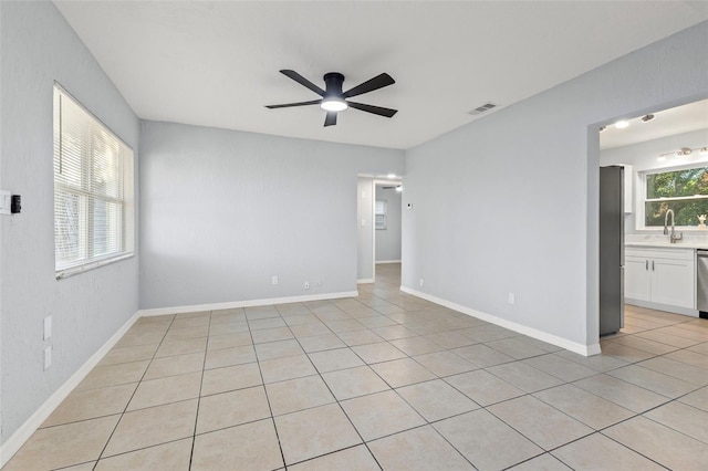 spare room featuring ceiling fan, light tile patterned floors, and sink