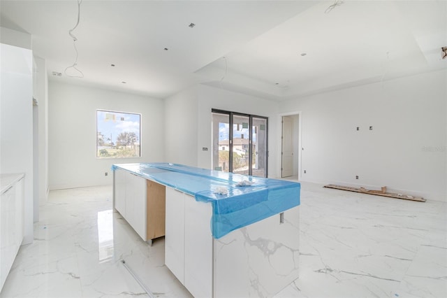 kitchen featuring a kitchen island, white cabinetry, and plenty of natural light