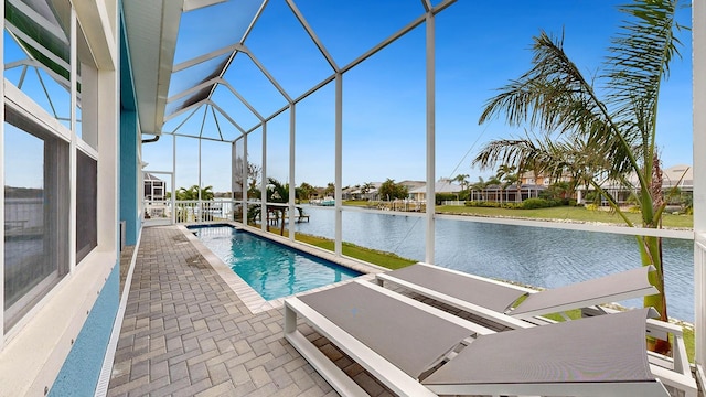 view of pool with glass enclosure, a water view, and a patio