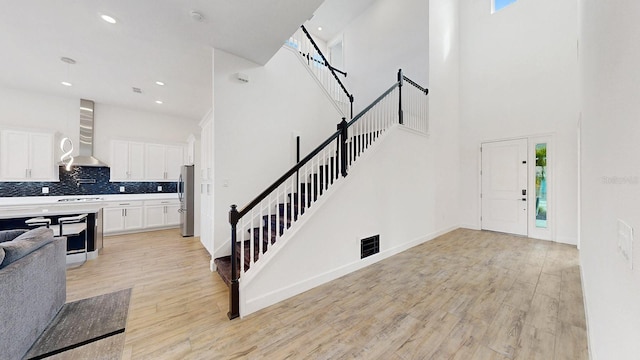 entryway with a high ceiling and light hardwood / wood-style flooring