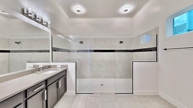 bathroom with a tile shower, tile patterned flooring, and vanity