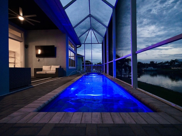 view of swimming pool featuring ceiling fan, a patio area, and a lanai