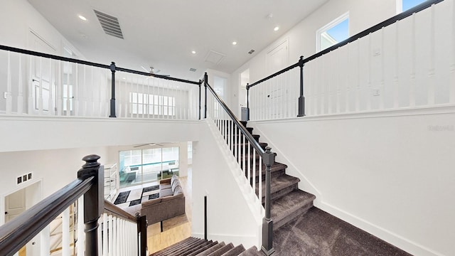 stairs featuring a wealth of natural light and a high ceiling