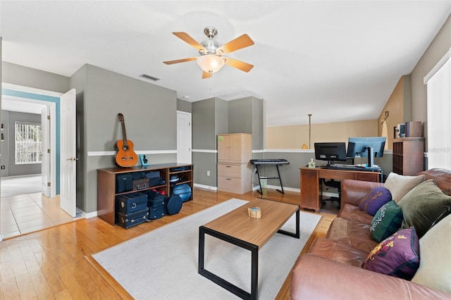 living room with ceiling fan and light hardwood / wood-style flooring