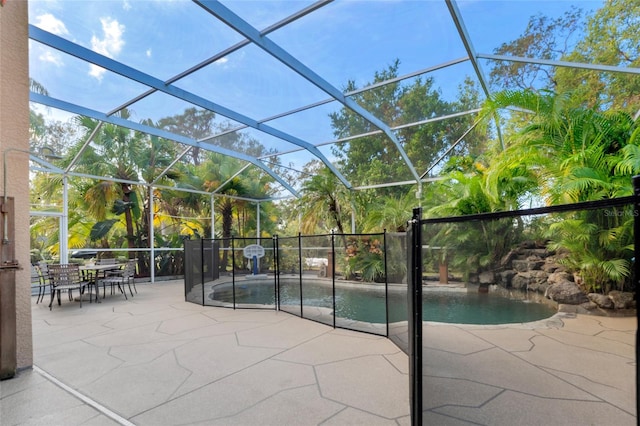 view of pool with glass enclosure and a patio area