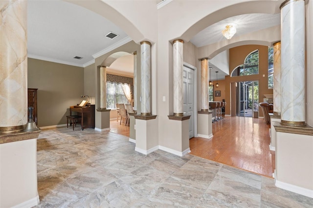 entryway with ornamental molding and decorative columns