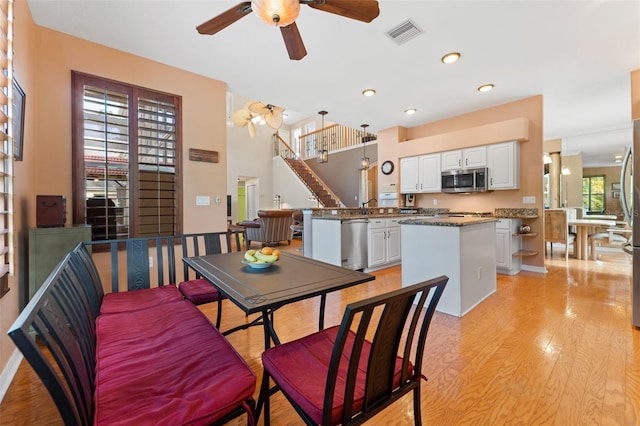 dining area with ceiling fan and light wood-type flooring