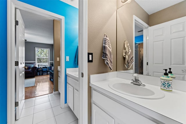 bathroom with a textured ceiling, tile patterned flooring, and vanity