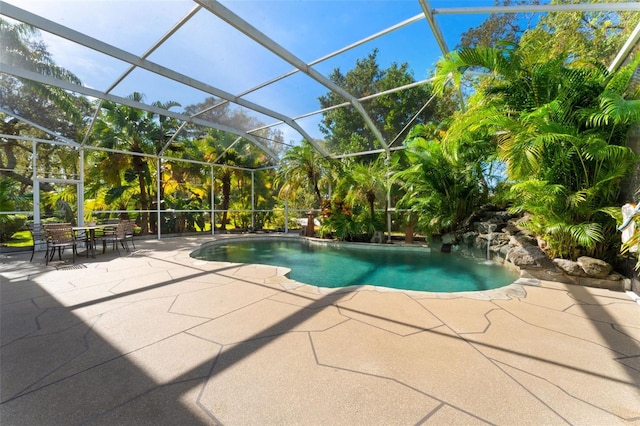 view of swimming pool with a patio and glass enclosure