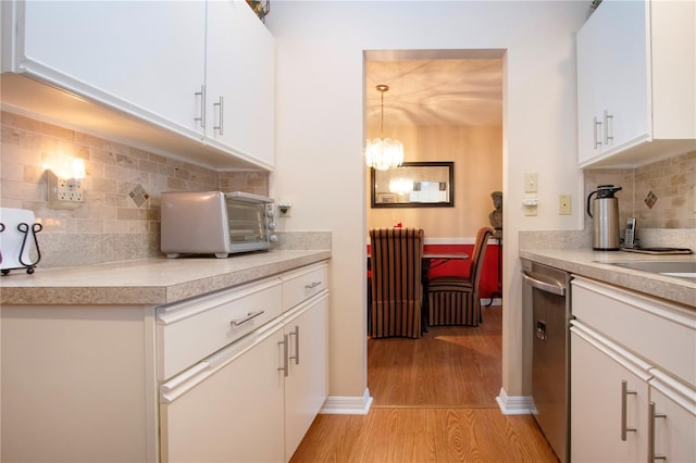 kitchen featuring white cabinetry, decorative light fixtures, dishwasher, light wood-type flooring, and decorative backsplash