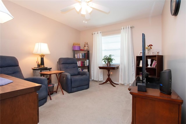 living area featuring light colored carpet and ceiling fan