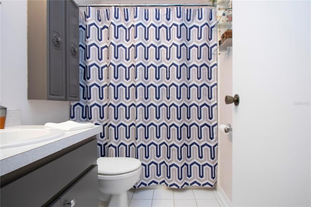 bathroom with toilet, vanity, tile patterned flooring, and curtained shower