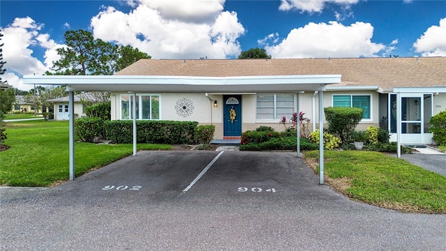 view of front of property featuring a front yard and a carport