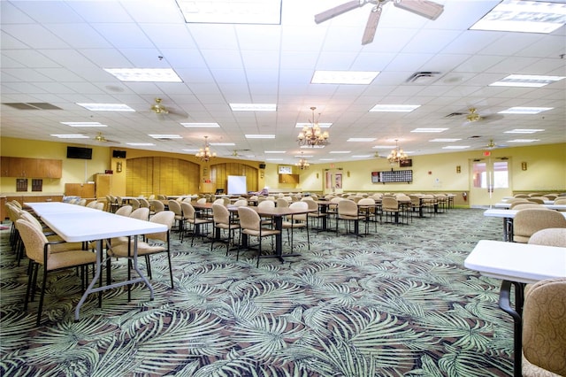 carpeted dining area with a drop ceiling