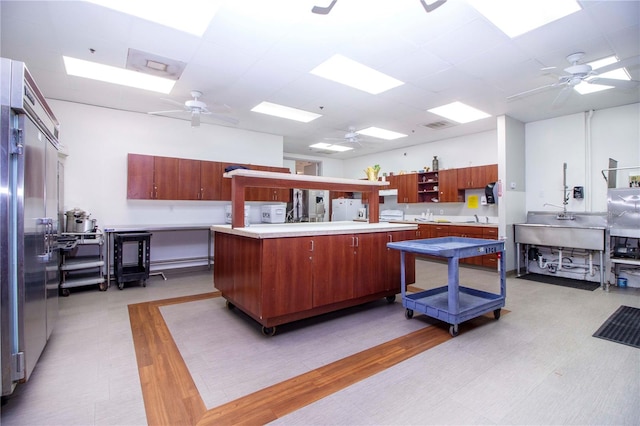 kitchen featuring a kitchen island, ceiling fan, white fridge, and light hardwood / wood-style floors