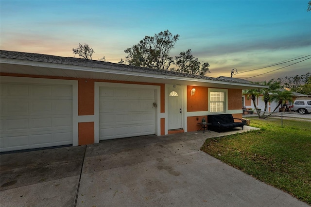 ranch-style house featuring a garage and a lawn