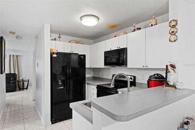 kitchen with kitchen peninsula, black appliances, light tile patterned floors, backsplash, and white cabinetry