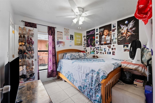 tiled bedroom featuring a textured ceiling and ceiling fan