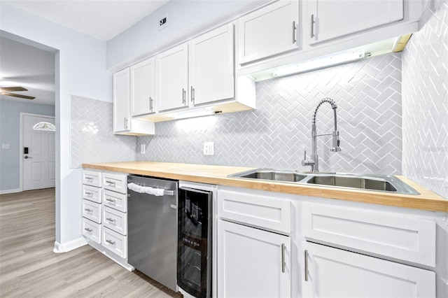 kitchen featuring wooden counters, dishwasher, sink, white cabinetry, and wine cooler