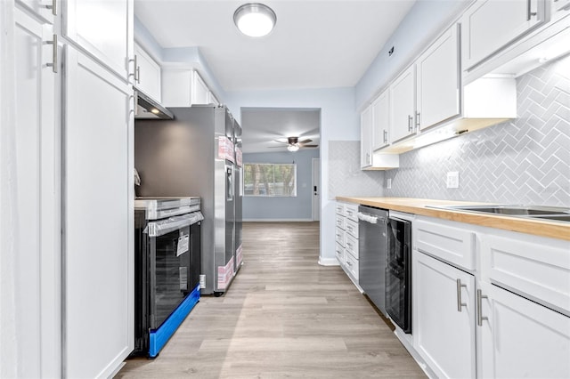 kitchen featuring white cabinets, ventilation hood, light hardwood / wood-style flooring, and electric range