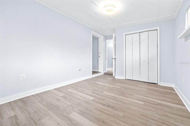 unfurnished bedroom with light hardwood / wood-style floors and a closet