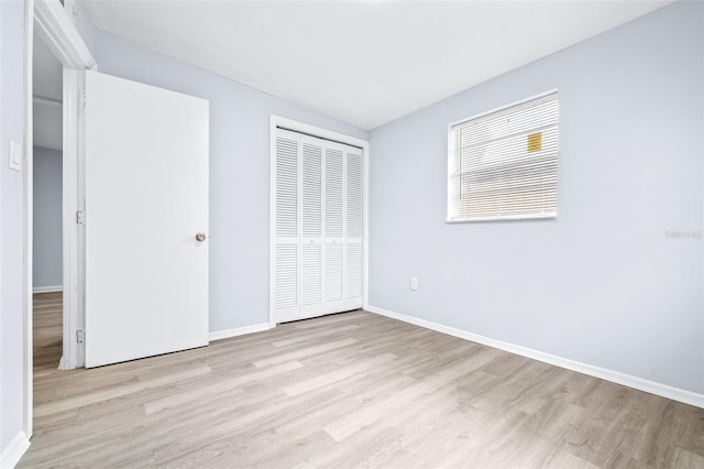 unfurnished bedroom with a closet and light hardwood / wood-style floors