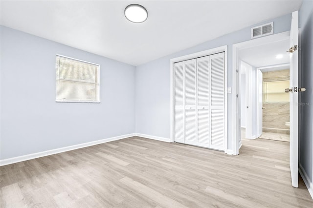 unfurnished bedroom with a closet and light hardwood / wood-style flooring