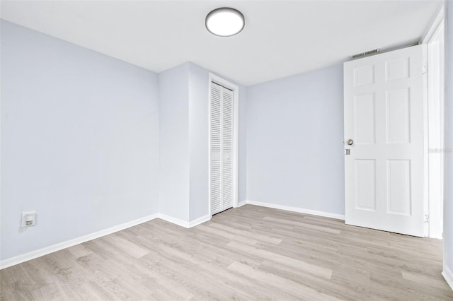 unfurnished bedroom with a closet and light hardwood / wood-style flooring