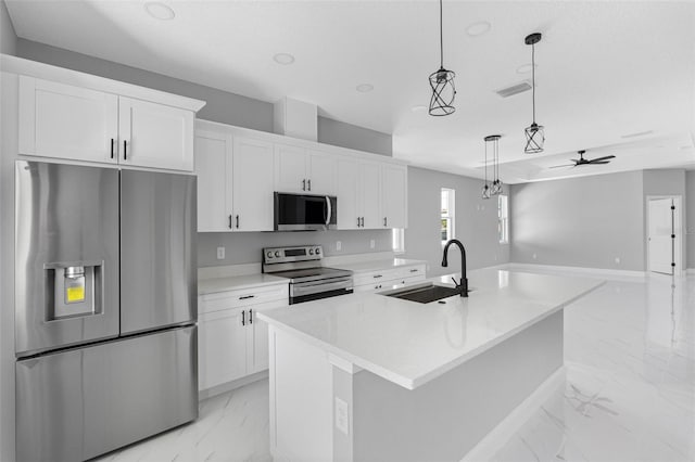 kitchen featuring stainless steel appliances, white cabinetry, sink, and a kitchen island with sink