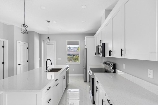 kitchen featuring stainless steel appliances, white cabinetry, hanging light fixtures, sink, and an island with sink