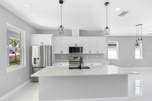 kitchen with white cabinets, stainless steel appliances, hanging light fixtures, and light stone countertops