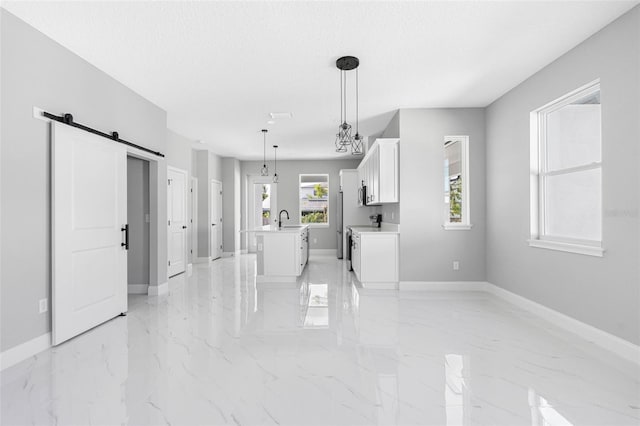 kitchen with a center island, white cabinets, hanging light fixtures, a textured ceiling, and a barn door